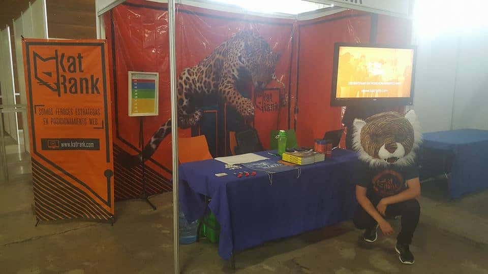 Un hombre presentando en Web Summit Mx 2017 con una mascota leopardo sobre una mesa.
