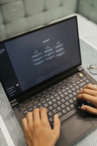 Una persona teclea en un ordenador portátil con el sitio web ChatGPT abierto en la pantalla.
