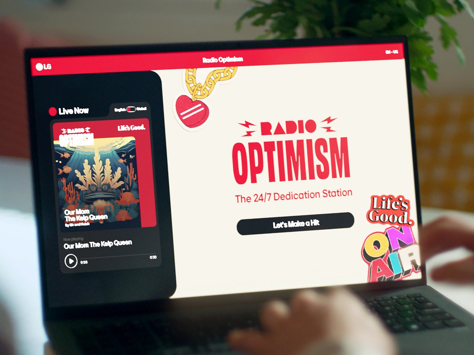 Una persona utiliza un ordenador portátil que muestra un sitio de transmisión de música llamado "Radio Optimism", que muestra una emisora en directo y la opción de hacer una dedicatoria de una canción.