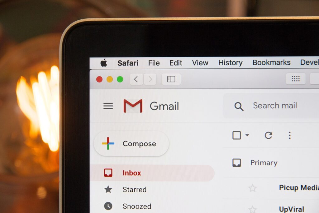 Primer plano de la pantalla de un ordenador portátil que muestra la interfaz de la bandeja de entrada de Gmail con el menú del navegador Safari visible en la parte superior.