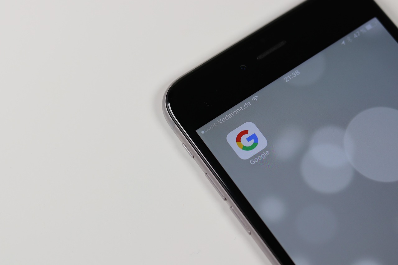 La pantalla de un smartphone muestra el icono de la aplicación de Google sobre un fondo gris y borroso.