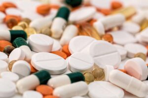 Una variedad de pastillas y cápsulas de diferentes formas, tamaños y colores esparcidas por una superficie.