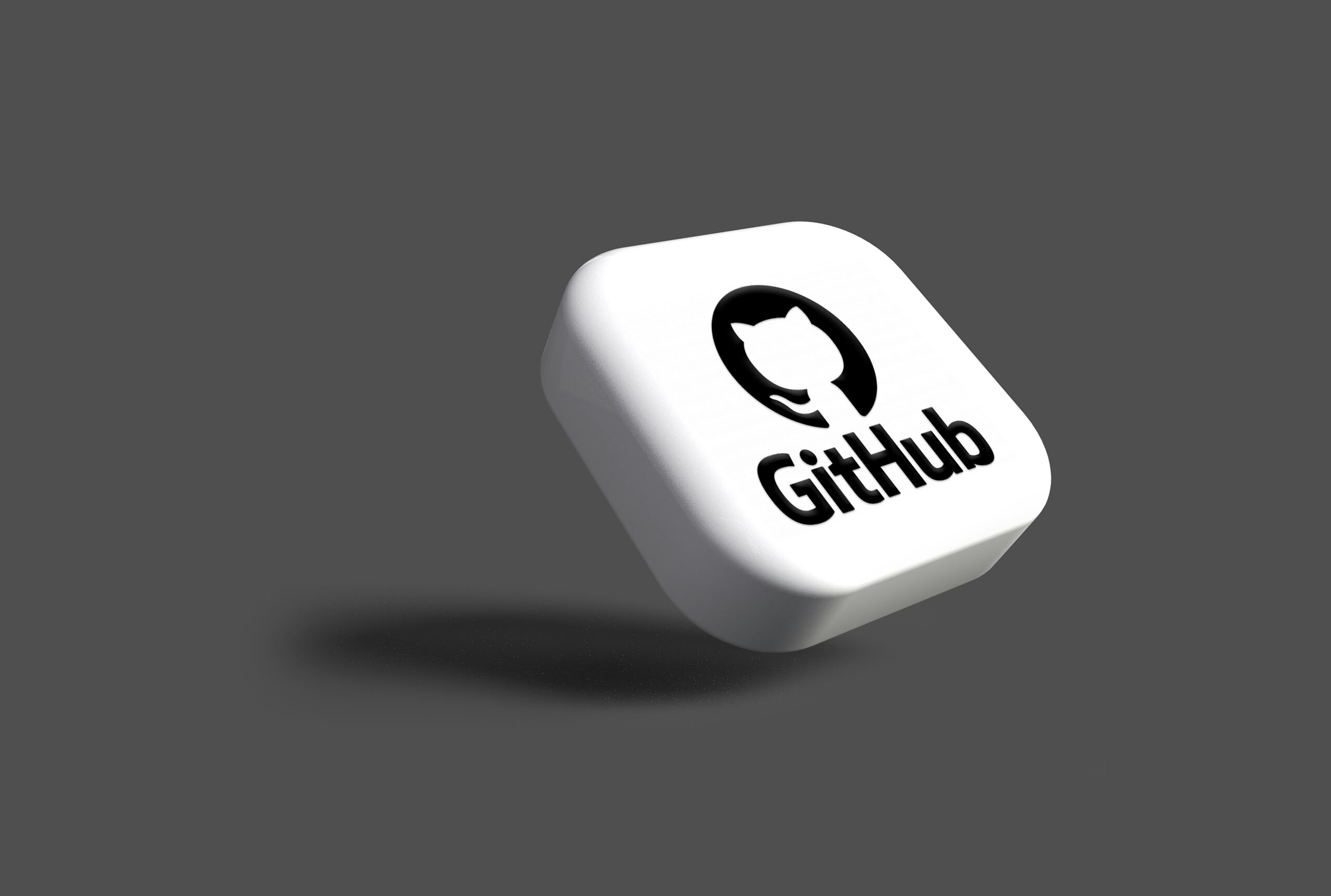 Un botón cuadrado blanco en 3D con el logotipo y el texto de GitHub, flotando sobre un fondo gris liso con una sombra debajo.