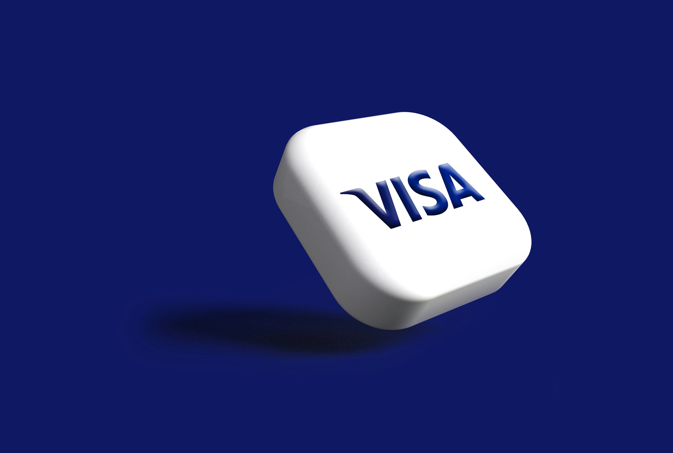 Un botón blanco cuadrado redondeado con el logotipo azul de Visa flota sobre un fondo sólido azul oscuro, proyectando una suave sombra.