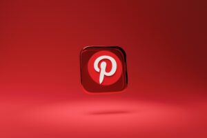 Un icono del logotipo de Pinterest en 3D sobre un fondo rojo sólido con una ligera sombra debajo.