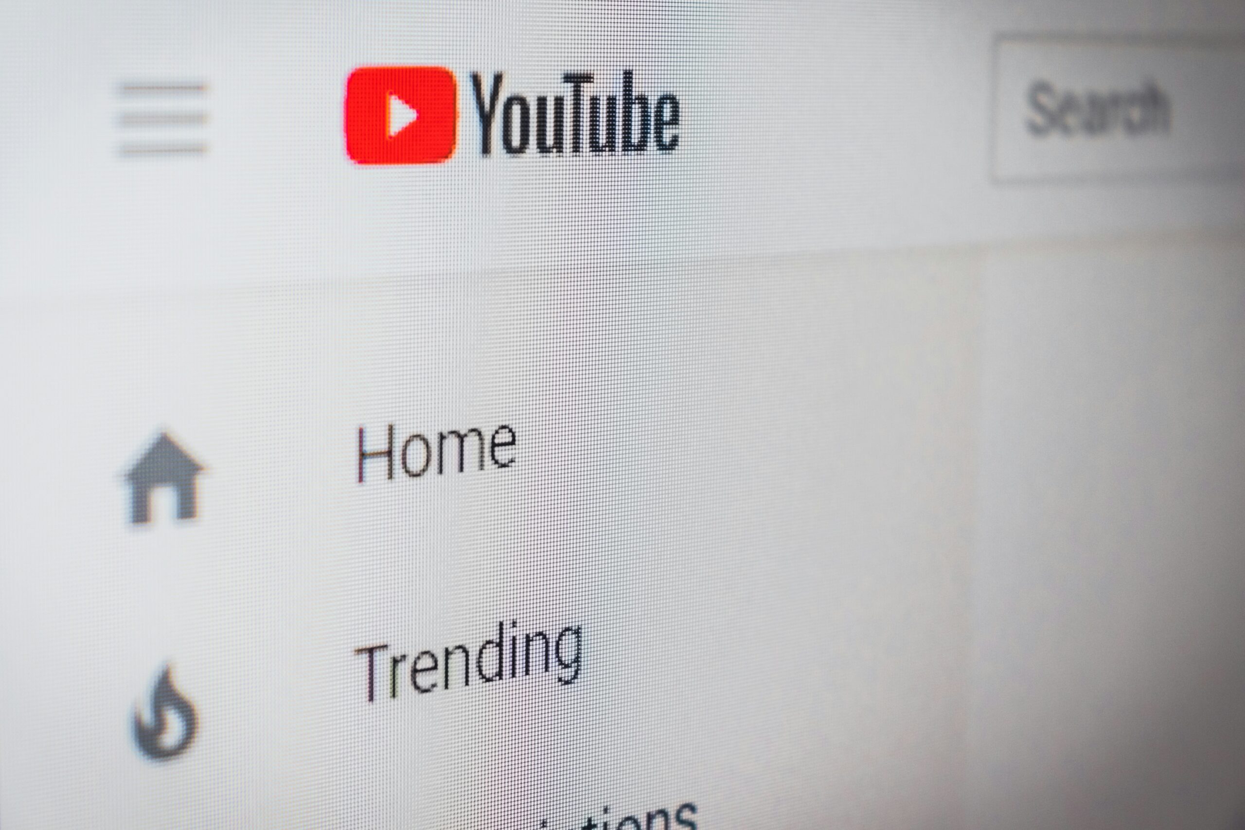 Interfaz del sitio web de YouTube que muestra el logotipo, la barra de búsqueda y las opciones de menú, incluidas Inicio y Tendencias en la barra lateral izquierda.