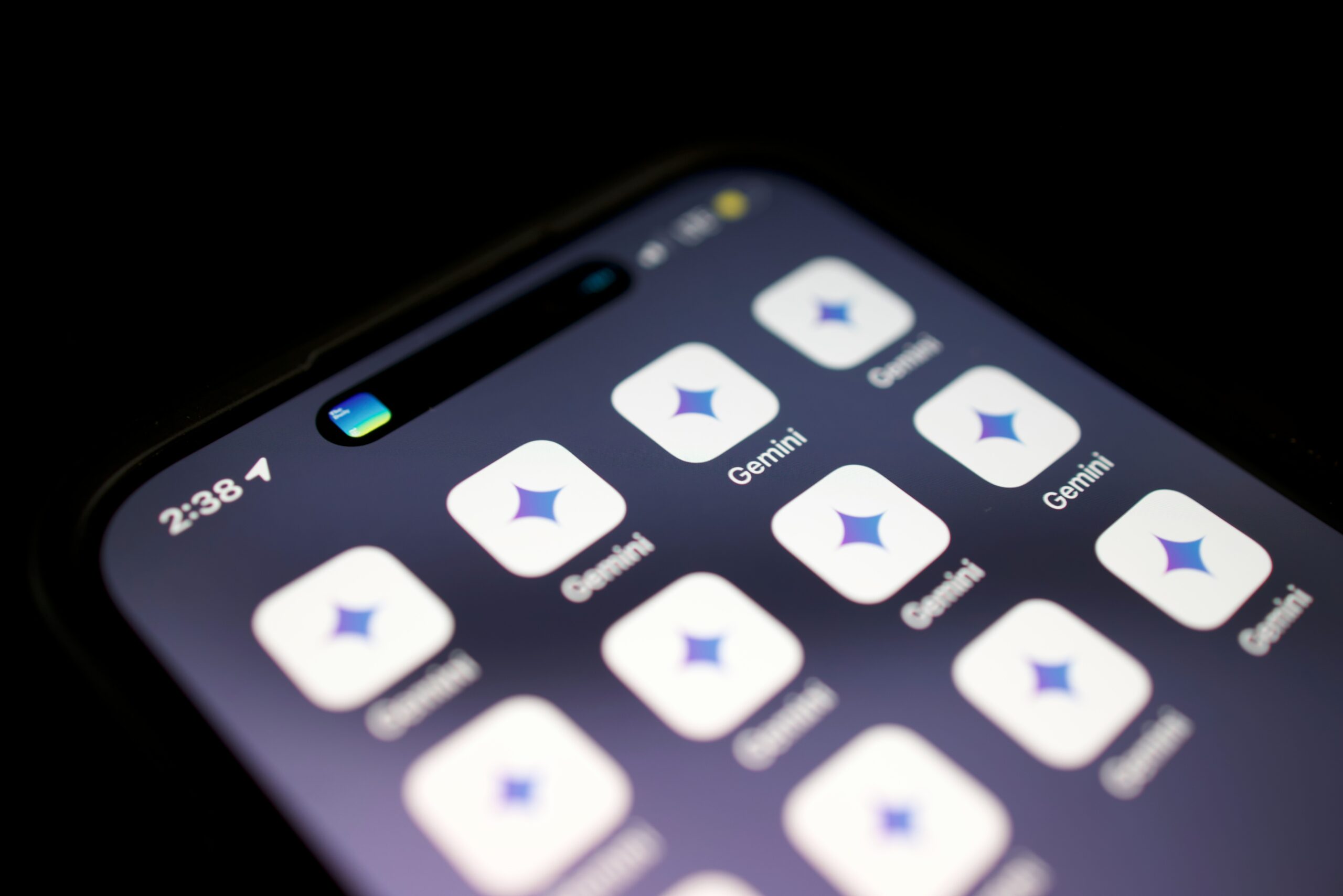 La pantalla de un smartphone muestra varios iconos de la aplicación Gemini, cada uno con un logotipo azul y morado en forma de estrella, y la hora marca las 2:38.