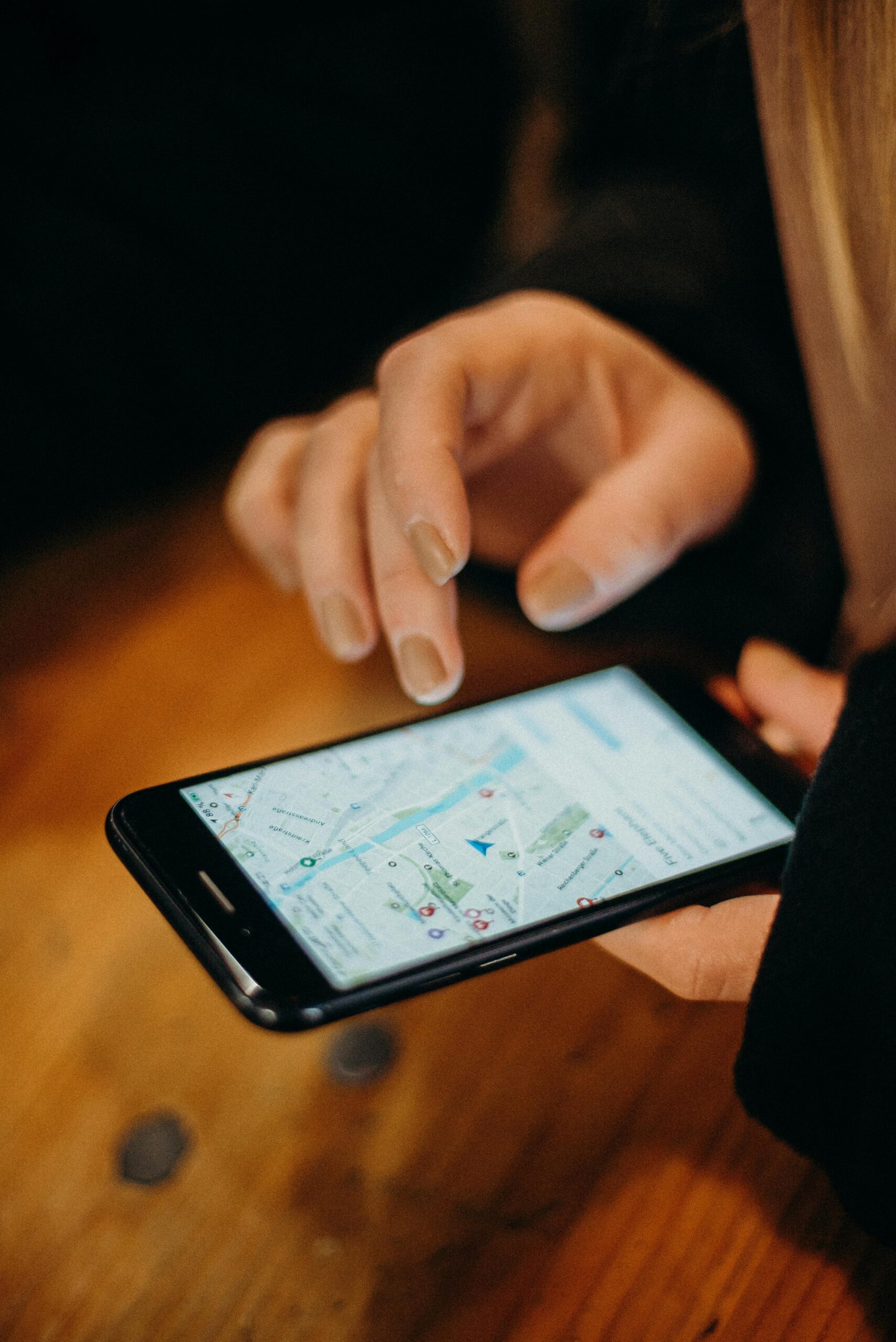 Una persona utiliza un smartphone con una aplicación de mapas abierta, mostrando su ubicación en la pantalla.