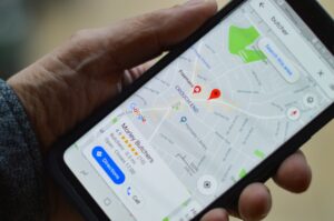 Una mano sostiene un smartphone que muestra Google Maps con indicaciones para llegar a una carnicería en Crouch End, Londres.