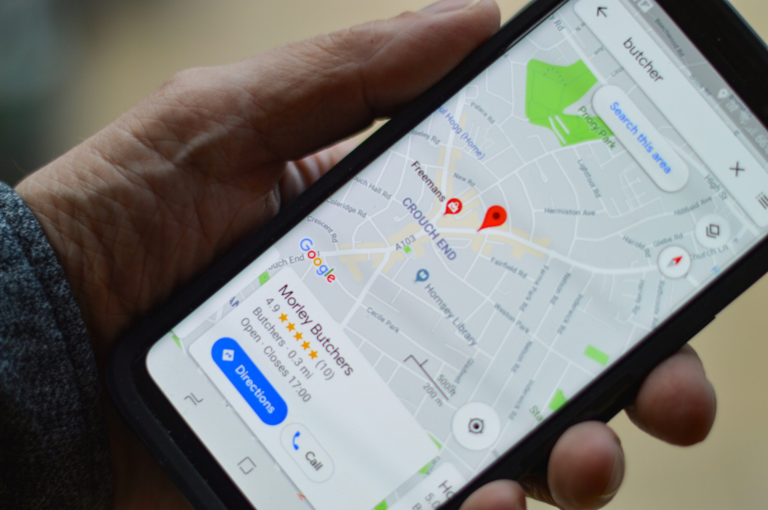 Una mano sostiene un smartphone que muestra Google Maps con indicaciones para llegar a una carnicería en Crouch End, Londres.