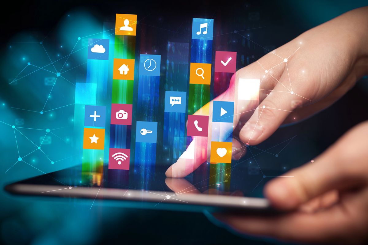 Primer plano de una persona usando una tableta, con coloridos iconos de aplicaciones digitales flotando sobre la pantalla, que representan diversas funciones sociales, de medios de comunicación y seo en tijuana utilidad.