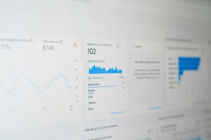 En la pantalla de un ordenador se muestran datos analíticos del sitio web, como recuento de usuarios, ingresos, gráficos de tráfico y una lista de los países más visitados por los usuarios.