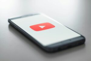 Un smartphone colocado sobre una superficie plana muestra el logotipo de YouTube en su pantalla.