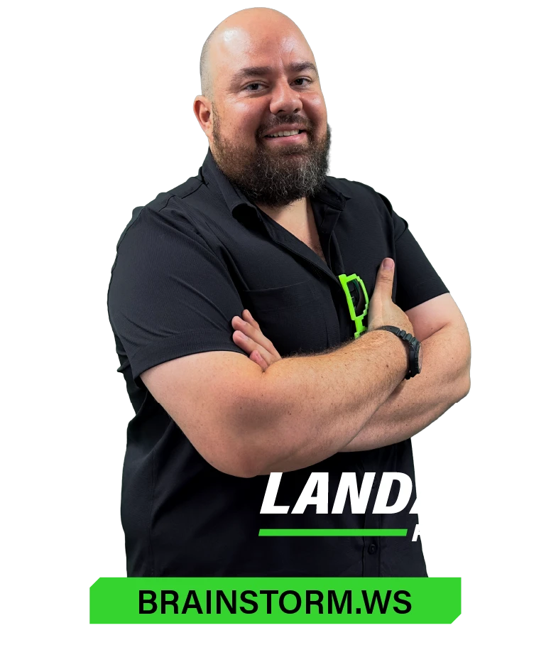 Hombre calvo con barba y camisa negra de pie con los brazos cruzados, sonriendo. El texto dice "LAND" y "BRAINSTORM.WS.".