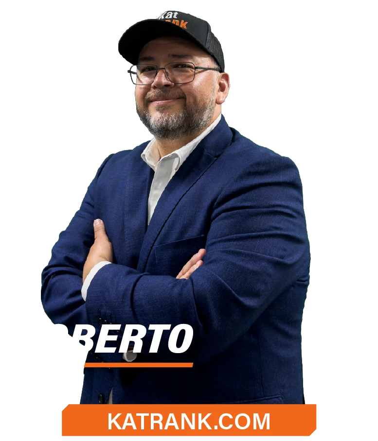 Un hombre con traje azul y gorra negra sonríe con los brazos cruzados. El texto superpuesto dice "KATRANK.COM.