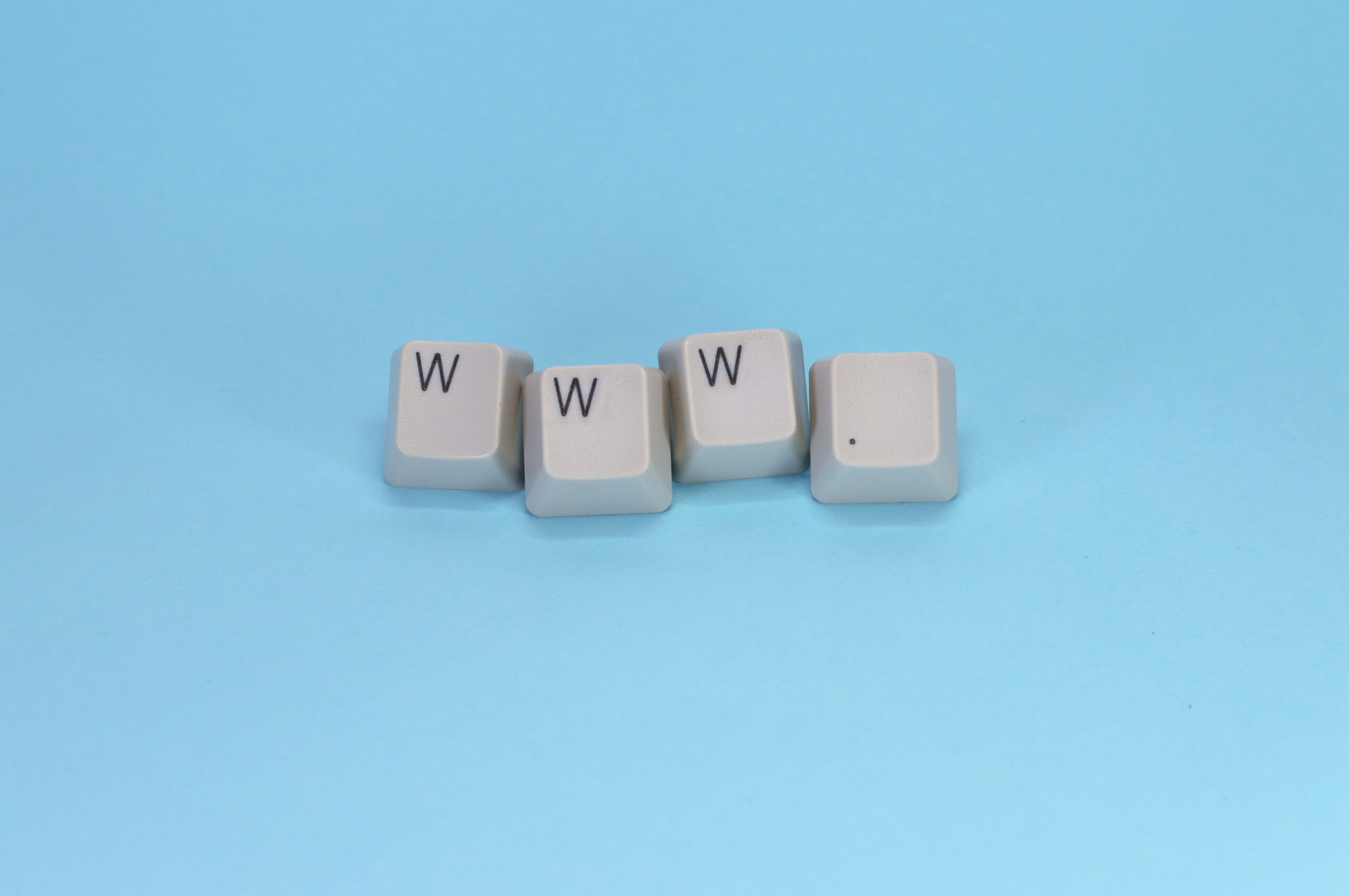 Cuatro teclas blancas dispuestas sobre un fondo azul escriben "www." con tres teclas W seguidas de un punto.