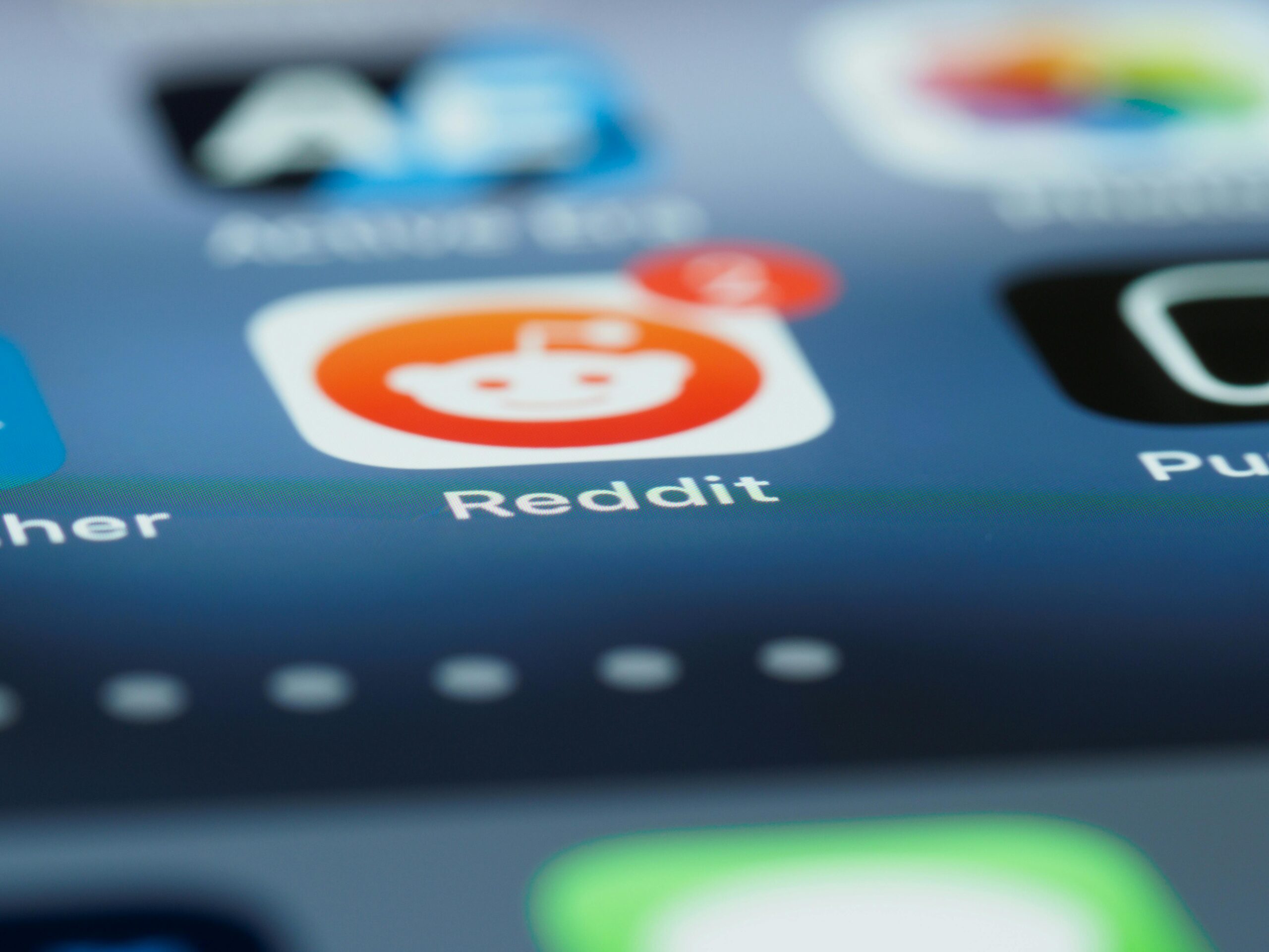 Primer plano de la pantalla de un smartphone que muestra el icono de la aplicación Reddit con una insignia de notificación que muestra el número 4.
