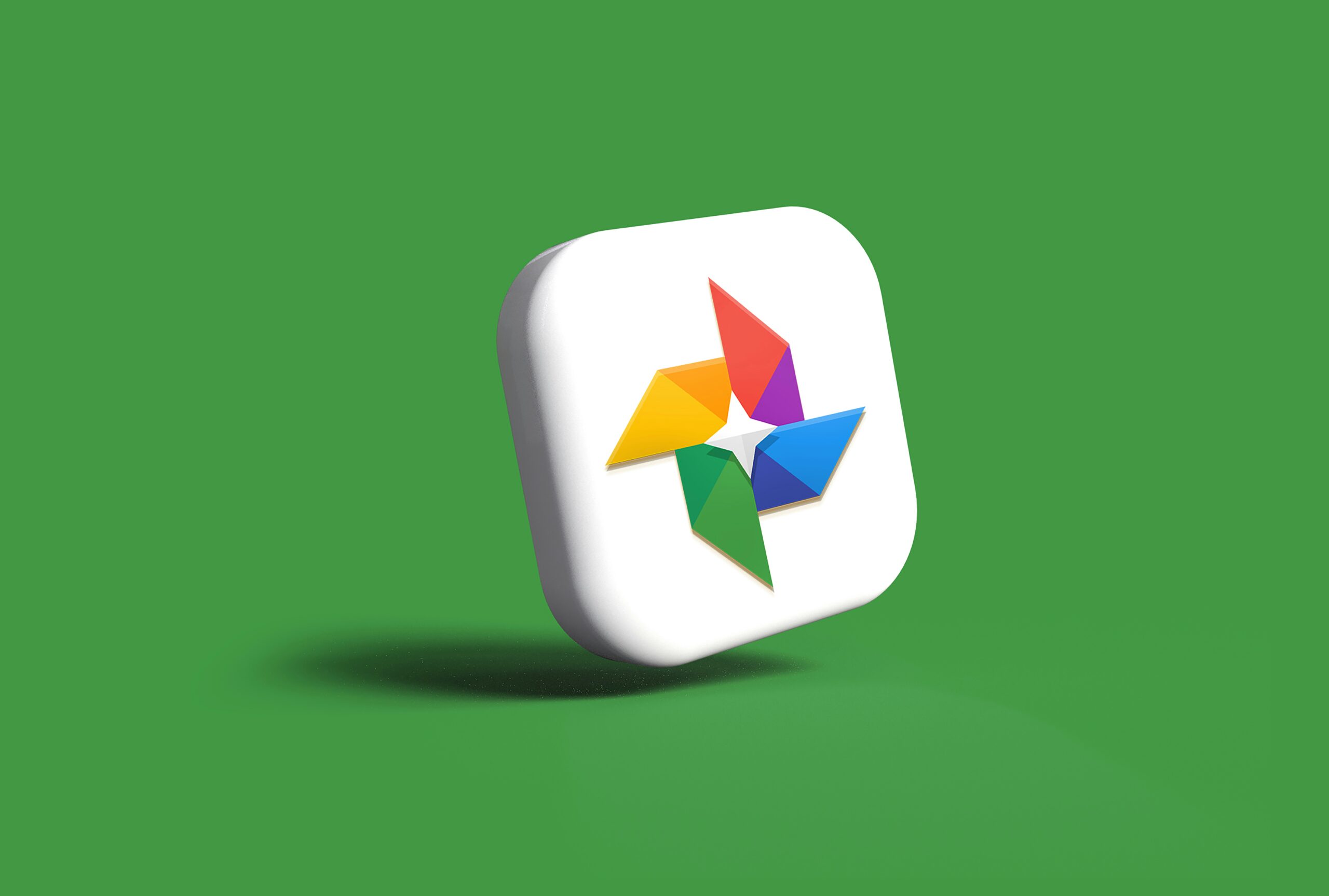 Icono en 3D con el logotipo de Google Fotos sobre un cuadrado blanco y un fondo verde sólido.