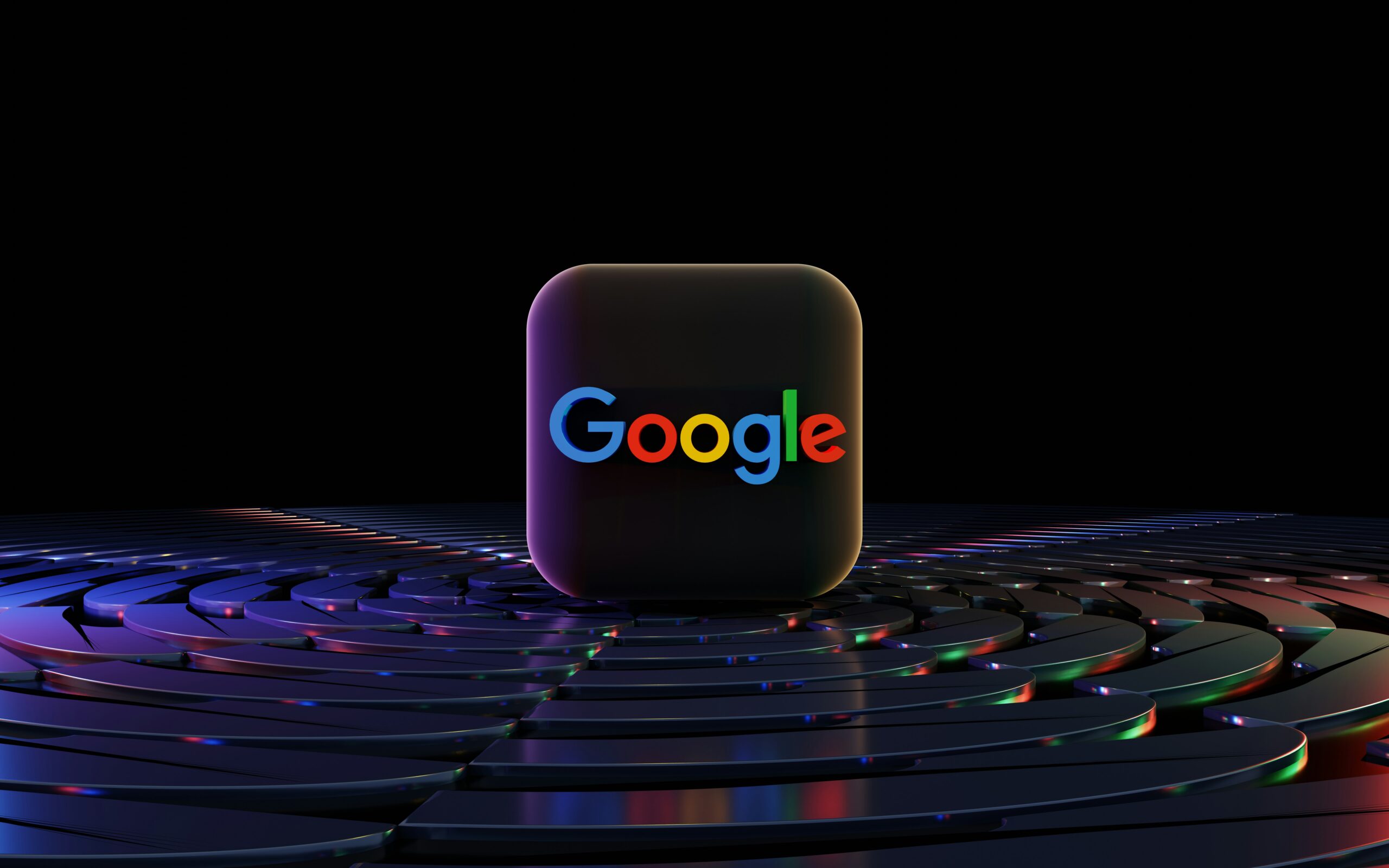 Un cubo negro en 3D con el logotipo de Google se alza sobre una superficie circular reflectante con reflejos de luz de colores sobre un fondo oscuro.