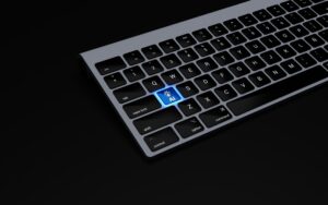 Un teclado de ordenador con una tecla azul que pone "IA" y el icono de una mano robótica, situada donde normalmente estaría la tecla de retorno.