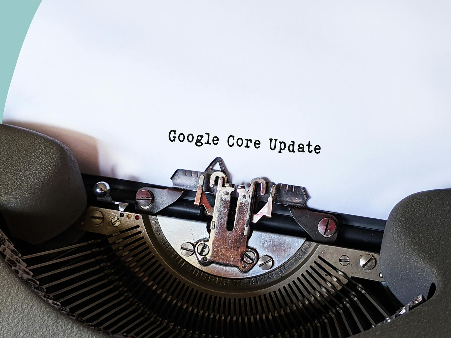 Primer plano de una máquina de escribir con una hoja en la que aparece escrito el texto "Google Core Update".