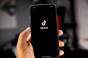 Una mano sostiene un teléfono inteligente que muestra el logotipo de la aplicación TikTok en la pantalla.