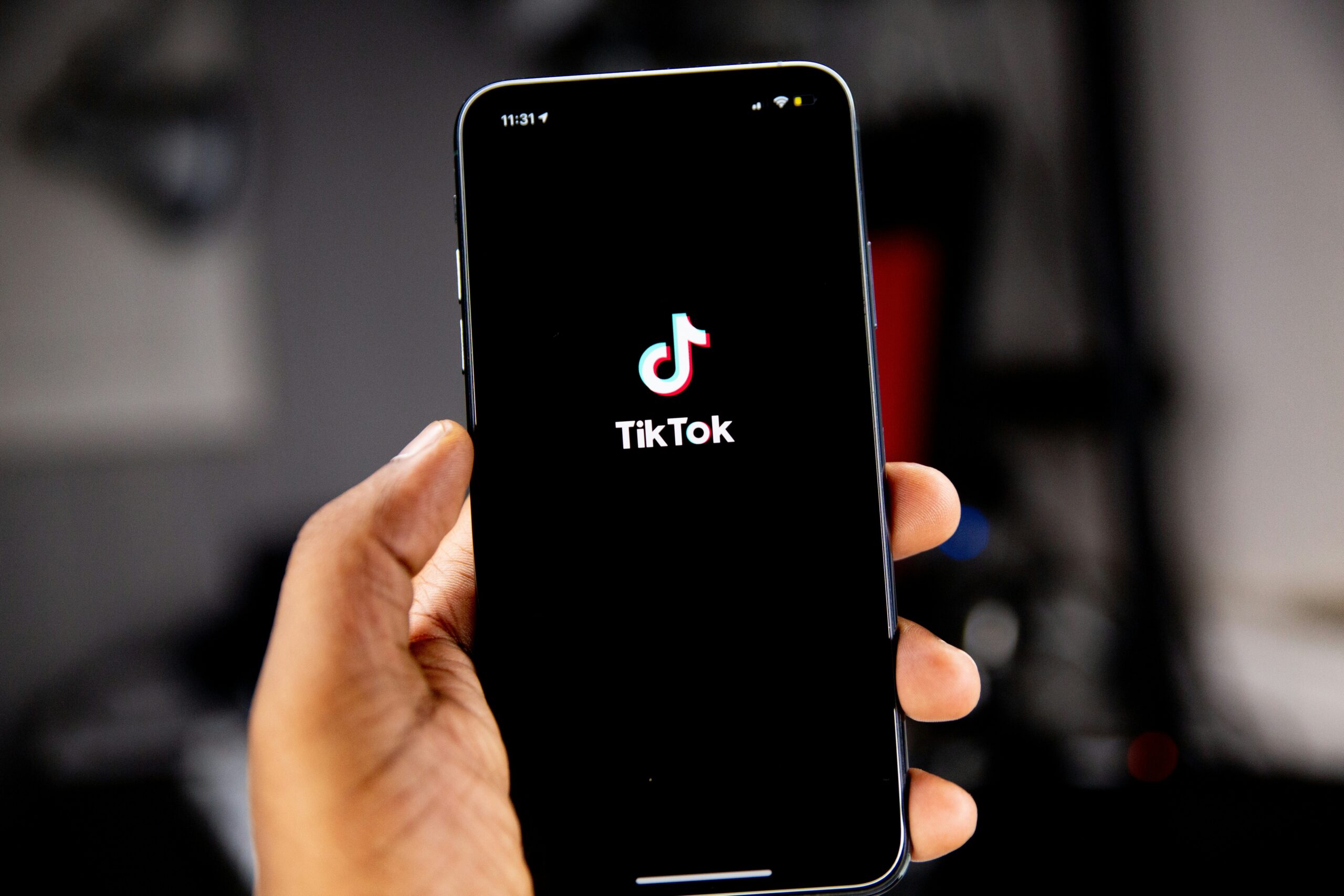 Una mano sostiene un teléfono inteligente que muestra el logotipo de la aplicación TikTok en la pantalla.