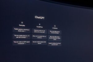 Una pantalla muestra la interfaz ChatGPT, con secciones de ejemplos, capacidades y limitaciones del modelo de IA sobre un fondo oscuro.