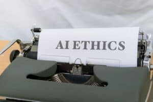 Una máquina de escribir con una hoja de papel en la que se lee "AI ETHICS" en letras grandes y en negrita.