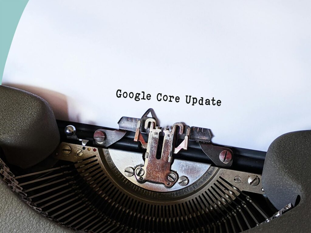 Primer plano de una máquina de escribir con una hoja en la que aparece el texto "Google Core Update" escrito en letras negras.