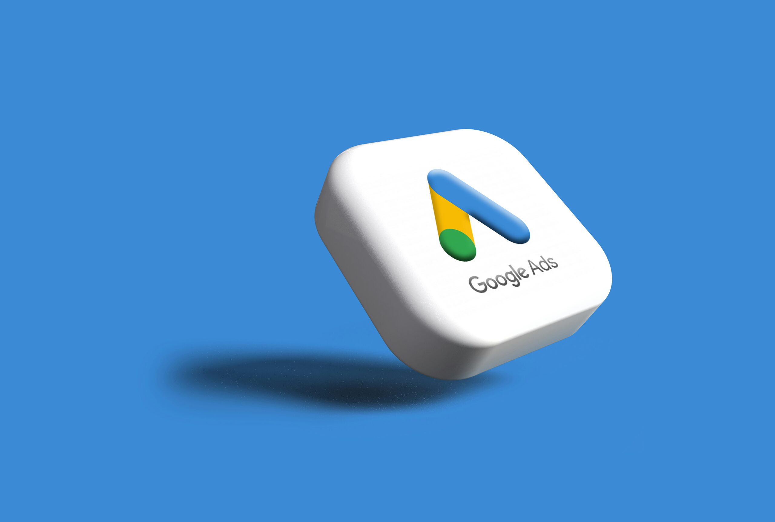 Icono cuadrado en 3D con el logotipo y el texto de Google Ads sobre un fondo azul sólido con una sombra debajo.